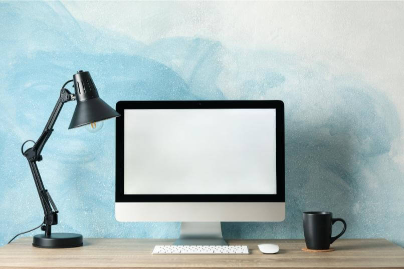 computer and lamp on desk with blue background 2026 03 25 00 09 56 utc